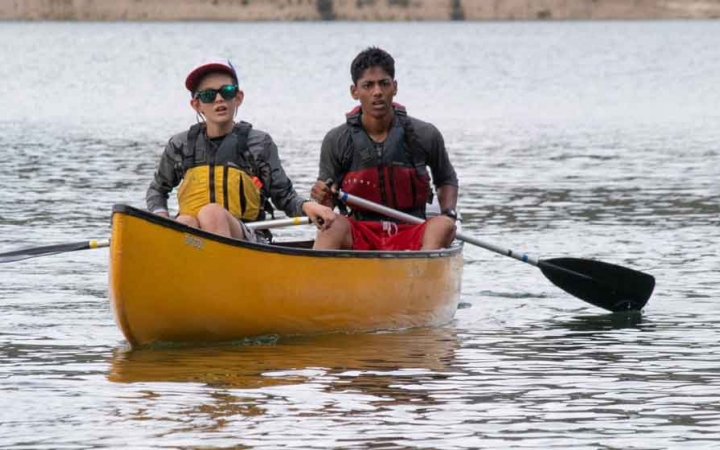 two boys paddle a yellow canoe on an outward bound course in the pacific northwest